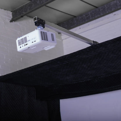 White projector mounted on ceiling arm for indoor golf simulator setup with impact screen