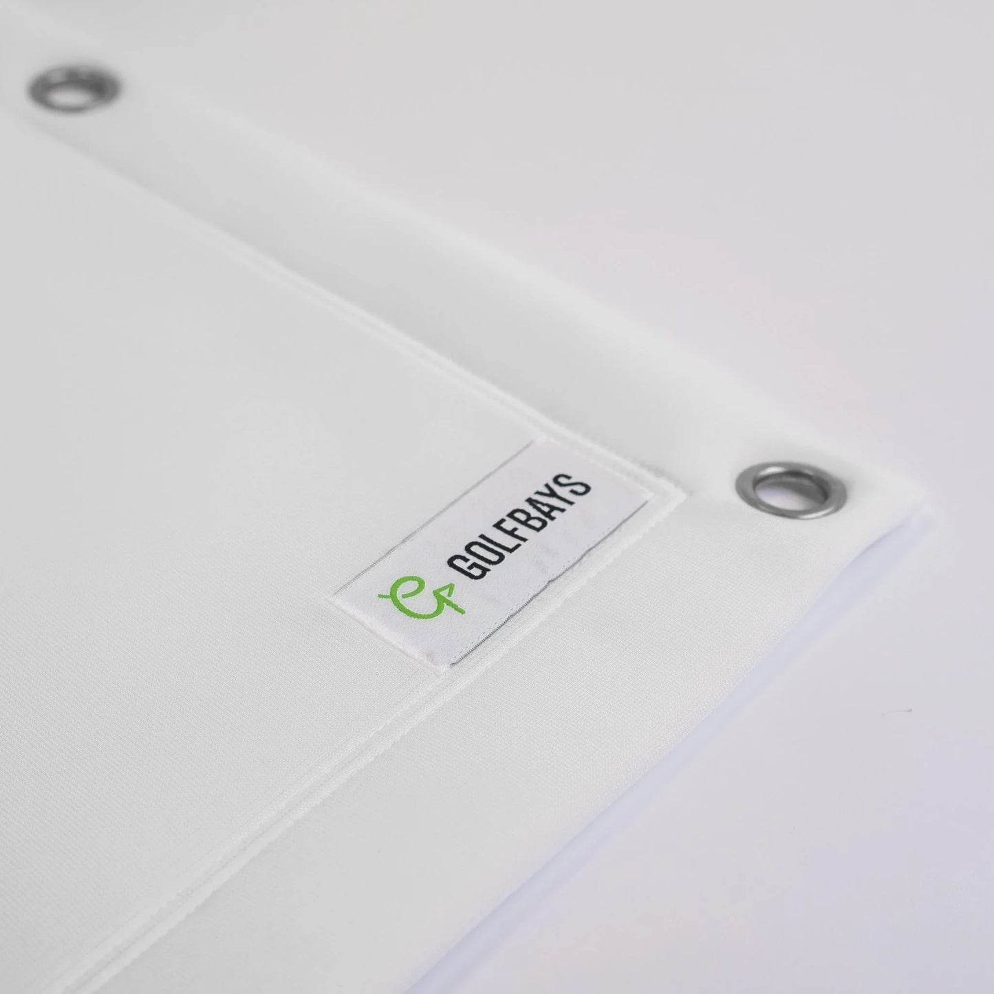 White golf simulator screen with GOLFBAYS logo tag and metal grommets for indoor golf setup