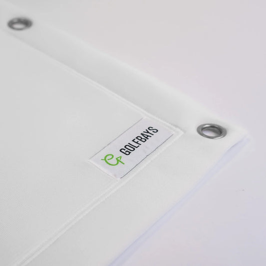 White golf simulator screen with GOLFBAYS logo tag and metal grommets for indoor golf setup