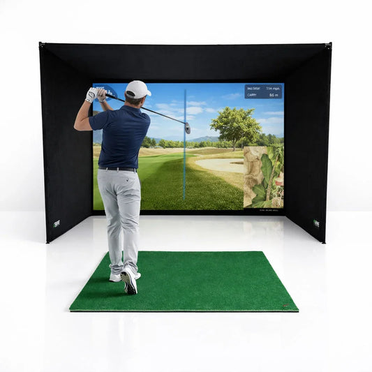 Golfer swinging in indoor golf simulator with impact screen, mat, and enclosure for home practice