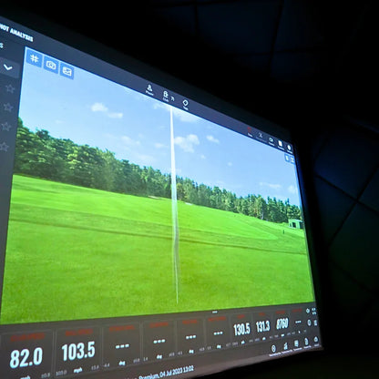 Golf simulator screen displaying shot analysis with stats and virtual course view