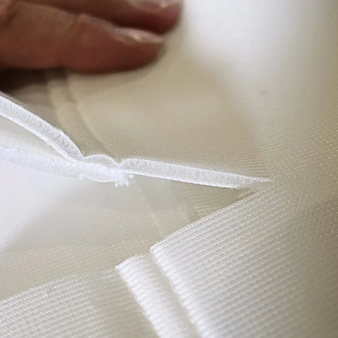 Close-up of durable white golf simulator impact screen fabric with reinforced stitching