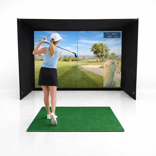 Woman swinging golf club on indoor simulator mat with impact screen displaying virtual course
